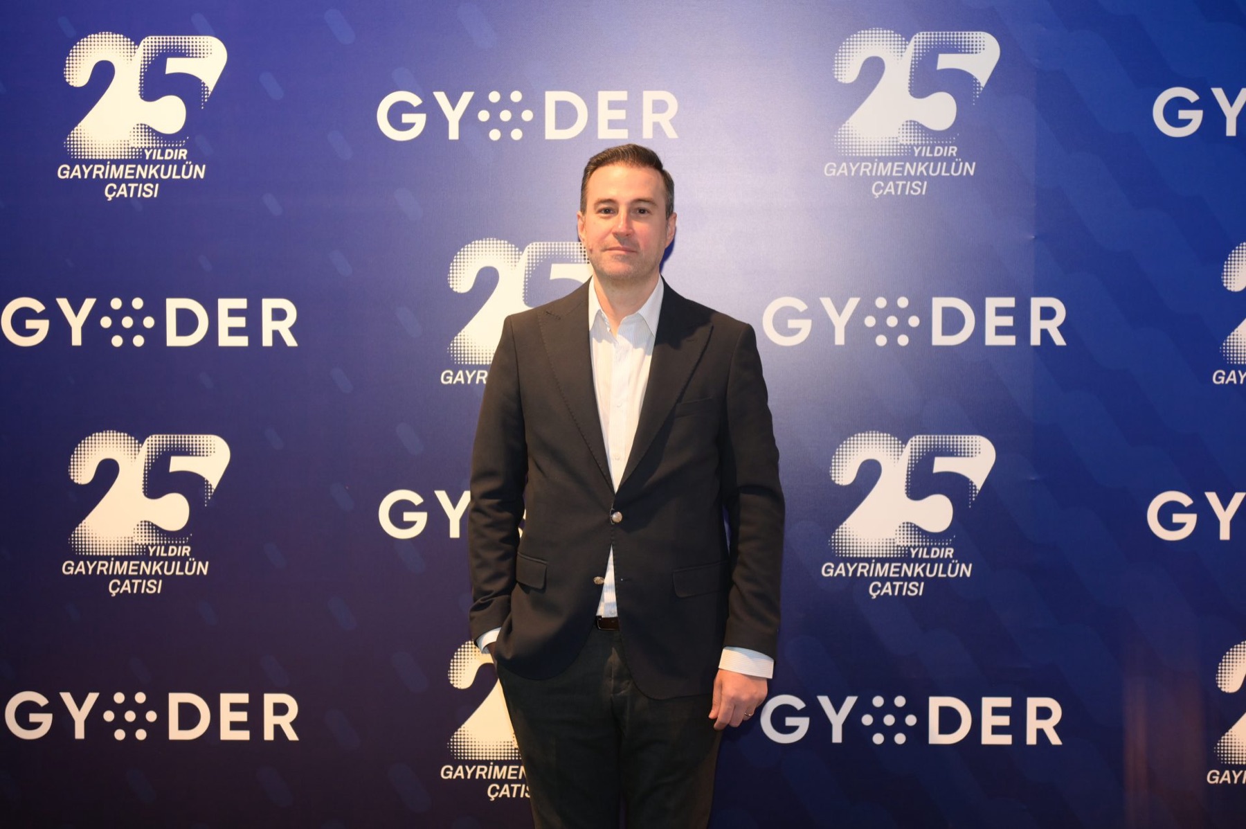 Guest in front of a branded anniversary photo backdrop