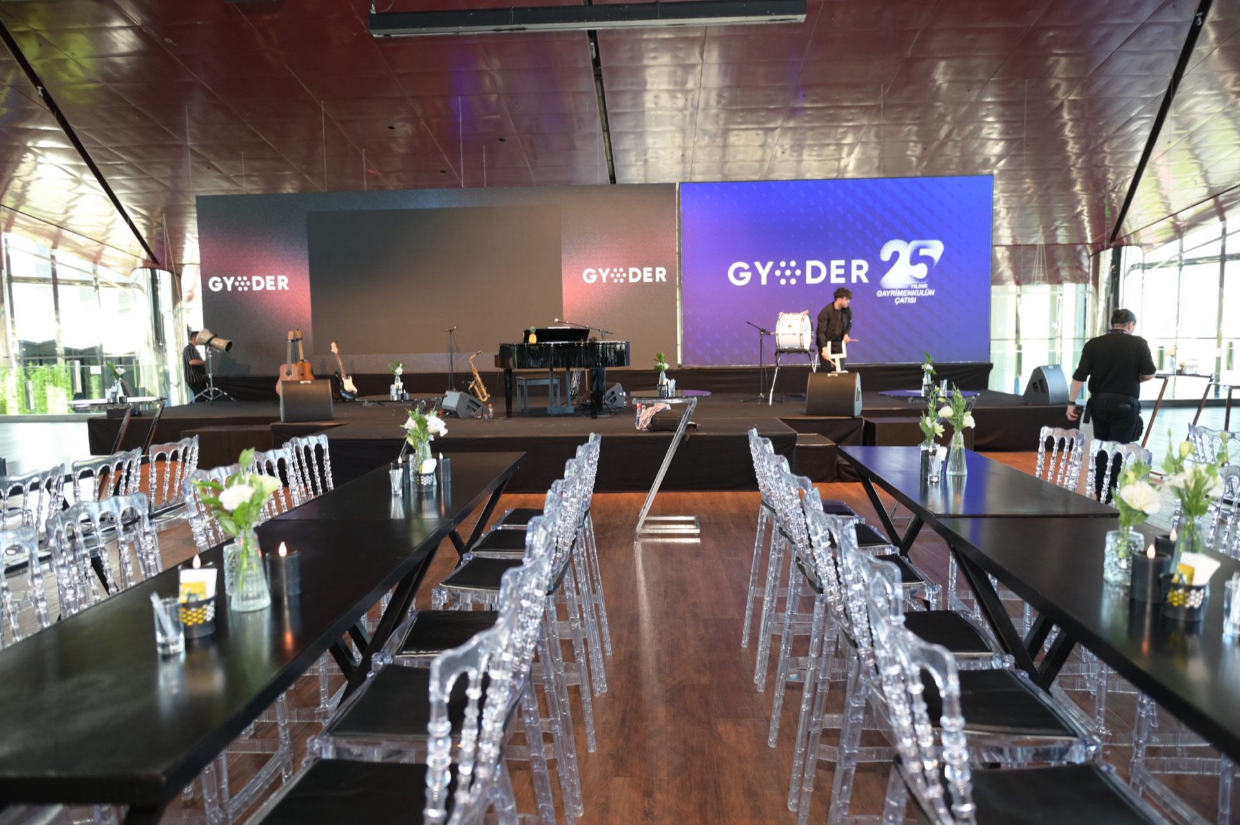 Gala hall with long tables facing a branded stage
